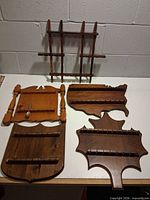 All five wooden spoon racks on tabletop showing shapes and slot rows