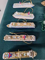 Five flat cruise ship ornaments laid out in a row
