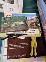 Stack showing postcards, Swiss booklet and Jack Hamm drawing handbook