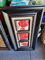 Black frame with three red poppy prints
