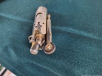 Side view of lighter showing striker arm and flint wheel