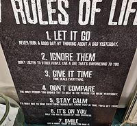 Canvas wall sign with "Rules of Life" text visible