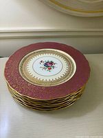 Stack of eight magenta and gold plates