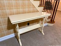 angled front view of off-white wood console table against wall
