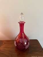 Full view of cranberry glass decanter with stopper