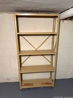 Full view of beige metal shelving unit with four shelves and cross brace