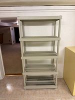 Front view of grey plastic shelving showing five tiers