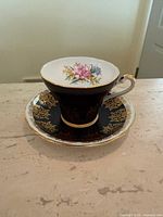 Teacup on saucer showing interior floral motif and exterior glaze