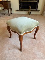 Overall view of footstool showing upholstery and legs