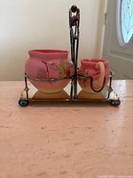 Front view of pink satin glass sugar and creamer set in silverplate stand