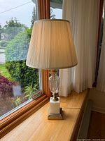 Full view of lamp on windowsill showing shade, crystal body, marble base