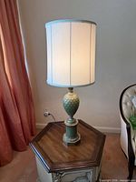 Full view of lit pineapple-form lamp with shade