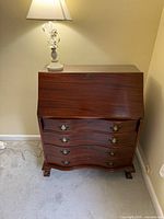 Full view of mahogany secretary desk closed, lamp on top for scale
