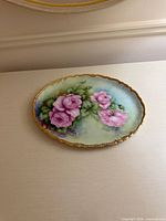 Front view of porcelain platter showing floral design and gold rim