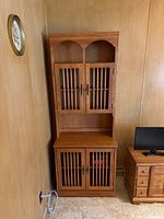 Full front view of cabinet showing slatted doors and open shelf