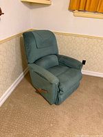 Full view of teal La-Z-Boy recliner angled in corner showing wooden lever