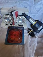 All items laid out: Dremel tool with charger and adapter, auxiliary spotlights, taillight lens kit