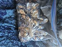 Bag containing numerous mixed-metal souvenir spoons