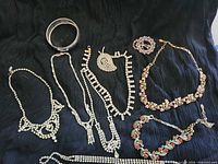 All eight jewelry pieces arranged on black fabric