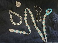Full view of all four jewelry pieces on black background