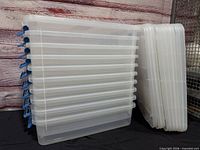 Stack of ten translucent bins with blue latches