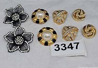 All four pairs of clip-on earrings grouped on white background
