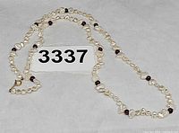 Full view of necklace showing pearls, garnet beads, and clasp
