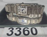 Front view of Cartier Tank stainless steel watch on mirror