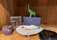 Shelf with carved stone bookend and lidded stone jar