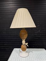 Full view of lamp with shade on white wicker surface