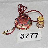Pendant and thimble together showing scale and design