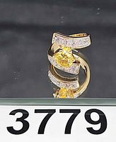Ring front view showing yellow center gem and pavé accents