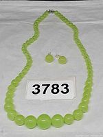 Necklace laid flat with earrings and lot number visible