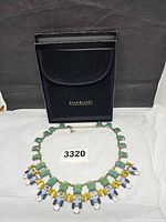 Full view of necklace laid flat with box behind
