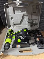 Open case showing drill, extra battery, charger and bits
