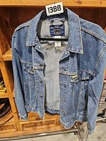 Front view of Levi Strauss Signature denim jacket on hanger showing overall condition and button front