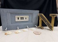 Overall lot showing letter, coat rack, five individual shells and shell medallion