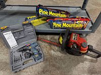 Lot overview with drill set, three firelogs, hedge trimmer
