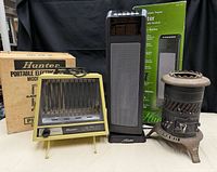 Group shot of both Hunter heaters with boxes and cast iron potbelly stove