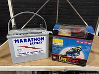 Front view of Marathon battery and boxed EverStart ES14LA2 battery