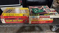 Stack showing Chess, Strawberry Shortcake, Stuff Yer Face, Othello, Monopoly, Twister, Operation boxes