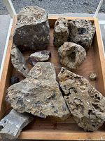 Tray containing multiple unpolished quartz geodes and rocks
