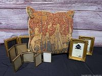 Group shot of pillow and gold picture frames