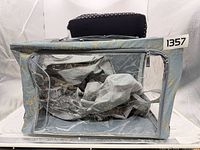 Front view blue floral storage box with clear window, grey inserts visible, black polka dot bag on top
