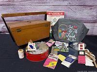 Full lot view showing wooden sewing box, project bag, stencil booklet, red tin, thread spool, packaged patches, bias tape, mending tape
