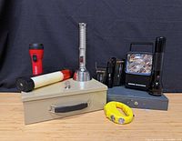 Group shot of all items: cash boxes, flashlights, worklight, battery packs, yellow safety light