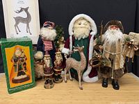 Group shot showing all Santa figurines, deer statue, and boxes