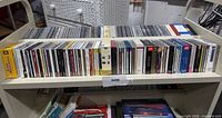 Full shelf view showing two rows of assorted audio CDs