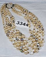 Full view of multi-strand faux pearl and crystal necklace with clasp visible