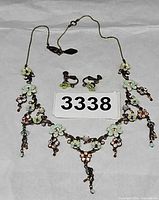 Full view of necklace and earrings set laid flat